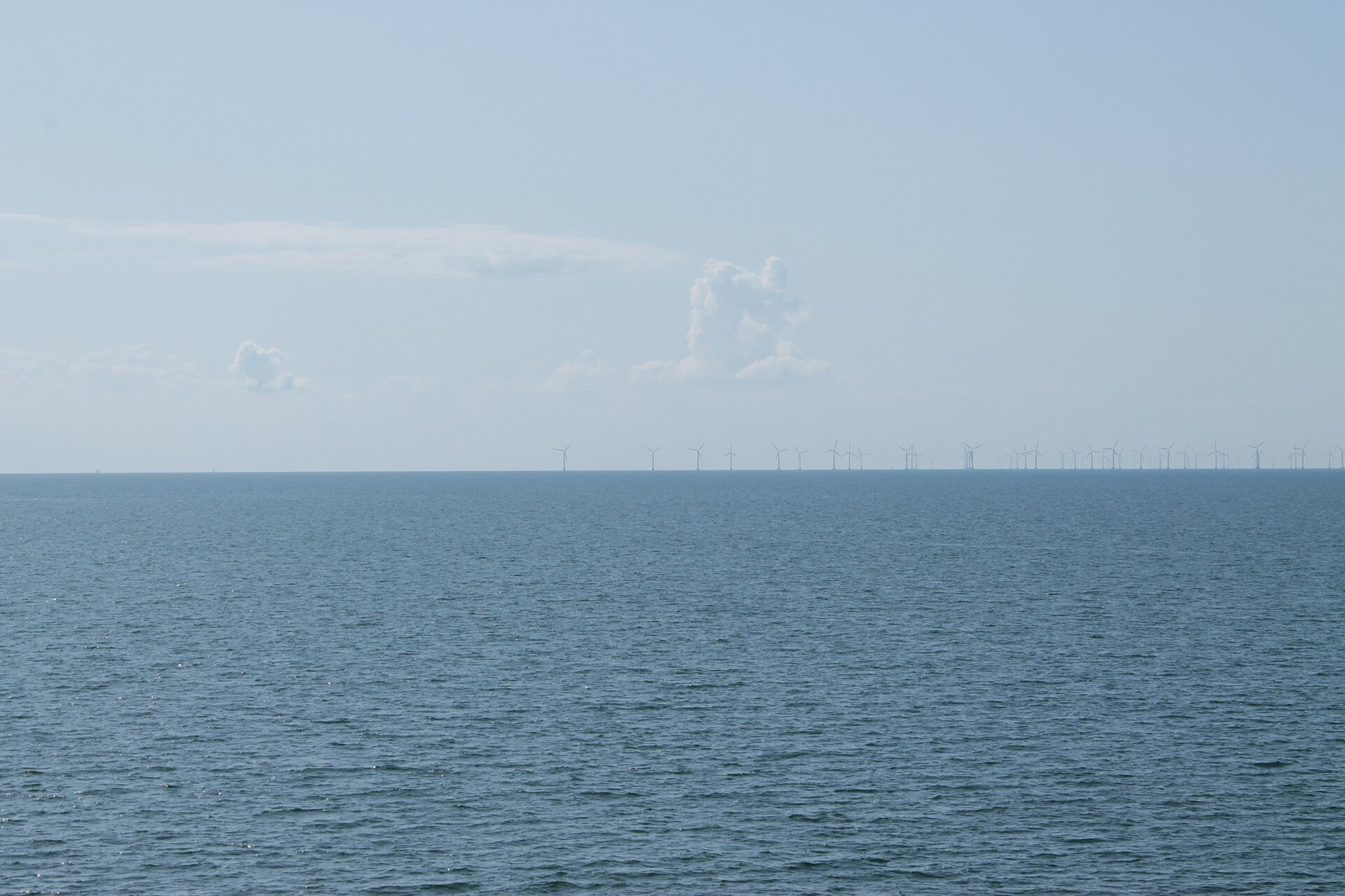 Offshore wind turbines on the horizon across open sea